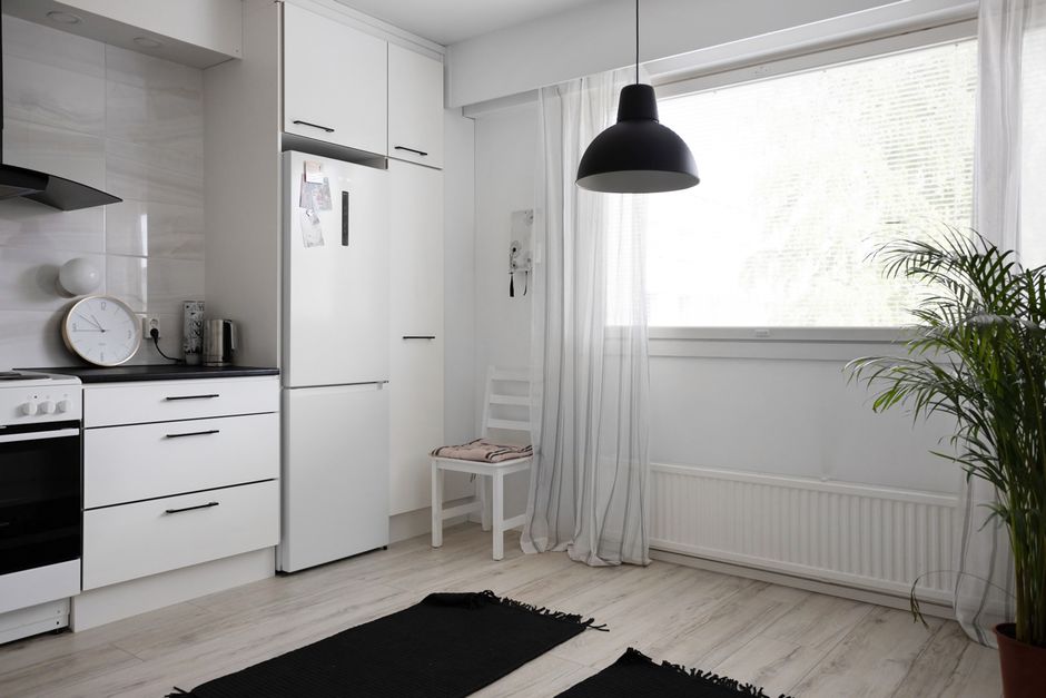 Cocina moderna luminosa con un frigorífico blanco integrado en los muebles