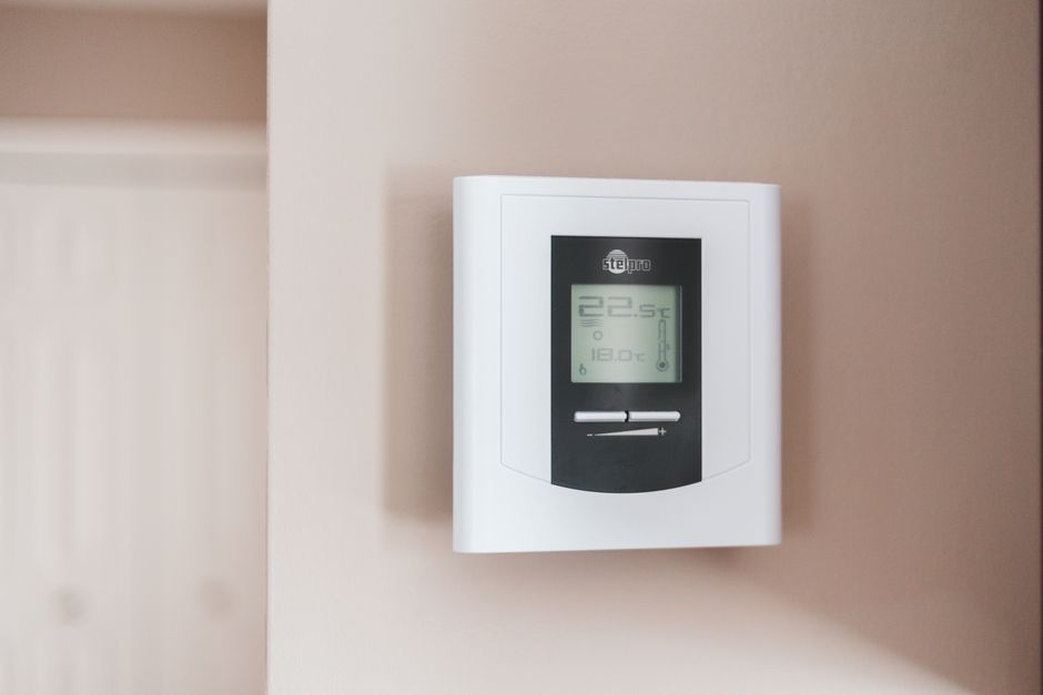 Termostato digital de pared marcando 22,5 grados en una vivienda